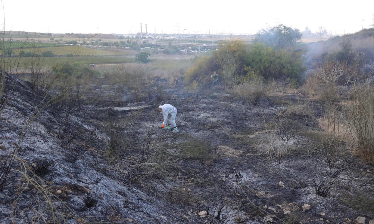 <span>An Israeli police bomb disposal unit examines the scene of a missile hit near Kfar Daniel in central Israel.</span><span>Photograph: Abir Sultan/EPA</span>