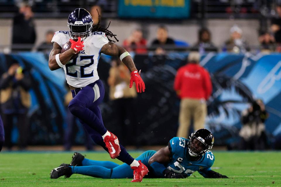 Tennessee Titans running back Derrick Henry (22) rushes for yards past Jacksonville Jaguars linebacker Foyesade Oluokun (23) during the second quarter of an NFL football regular season matchup AFC South division title game Saturday, Jan. 7, 2023 at TIAA Bank Field in Jacksonville. The Jacksonville Jaguars held off the Tennessee Titans 20-16. [Corey Perrine/Florida Times-Union]