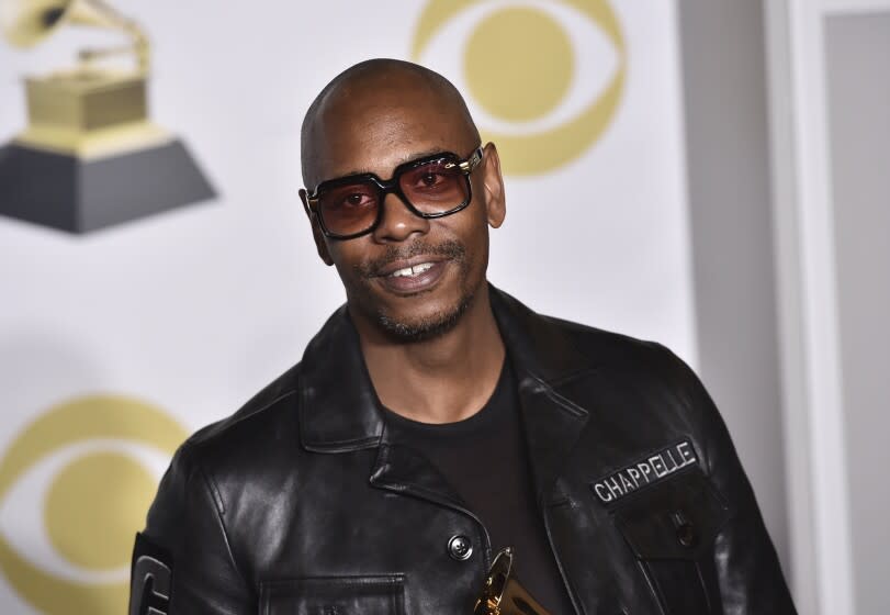 FILE - In this Jan. 28, 2018 file photo, Dave Chappelle poses in the press room with the best comedy album award for "The Age of Spin" and "Deep in the Heart of Texas" at the 60th annual Grammy Awards in New York. Netflix said Friday, Oct. 15, 2021 that it had fired an employee for disclosing confidential financial information about what it paid for Dave Chappelle's comedy special "The Closer," which some condemned as being transphobic. (Photo by Charles Sykes/Invision/AP, File)