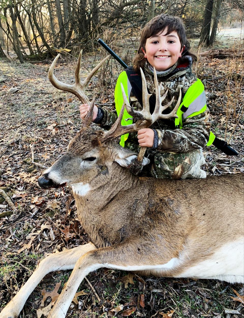 Mason Berryhill, 11, holds up the antlers of a 22-point buck he helped shoot with his dad.