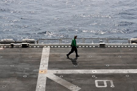 A U.S. sailor walks on the flight deck of USS Boxer (LHD-4) in the Arabian Sea off Oman