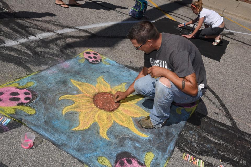 Barrett Dvorsky of Riga finishes his colorful freehand drawing during the 11th annual Art at Your Feet street art festival Aug. 24, 2019, in downtown Blissfield.