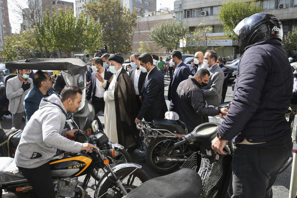 In this photo released by the official website of the office of the Iranian Presidency, President Ebrahim Raisi waves during a visit to a gas station in Tehran, Iran, Wednesday, Oct. 27, 2021. Raisi said Wednesday that a cyberattack which paralyzed every gas station in the Islamic Republic was designed to get "people angry by creating disorder and disruption," as long lines still snaked around the pumps a day after the incident began. (Iranian Presidency Office via AP)