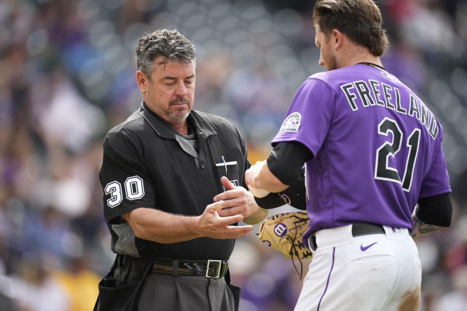 Home plate umpire Rob Drake, left, checks Colorado Rockies starting pitcher Kyle Freeland in the fourth inning of a baseball game against the Pittsburgh Pirates, Monday, June 28, 2021, in Denver. (AP Photo/David Zalubowski)