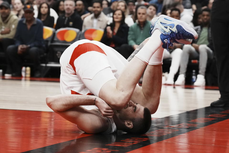 Toronto Raptors' Juancho Hernangomez clutches his ankle as he goes down during the first half of an NBA basketball game, Saturday, Dec. 3, 2022 in Toronto. (Chris Young/The Canadian Press via AP)