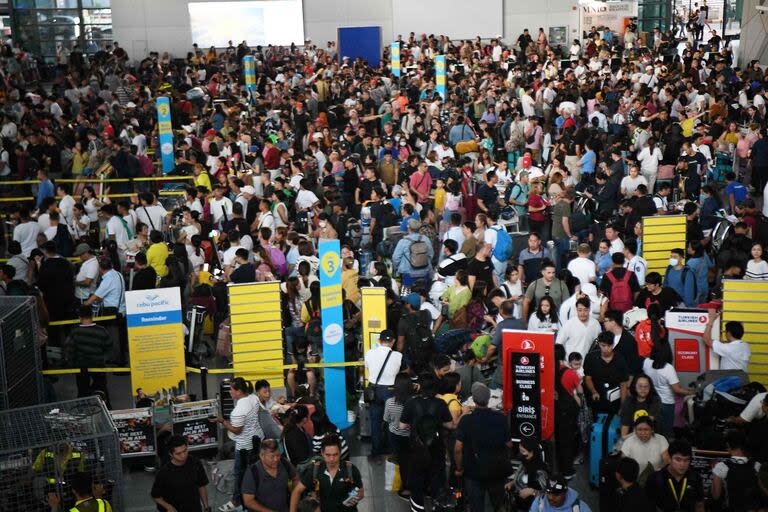 Los pasajeros se agolpan en los mostradores de salida de la aerolínea Cebu Pacific en la Terminal 3 del aeropuerto internacional Ninoy Aquino en Manila el 19 de julio de 2024