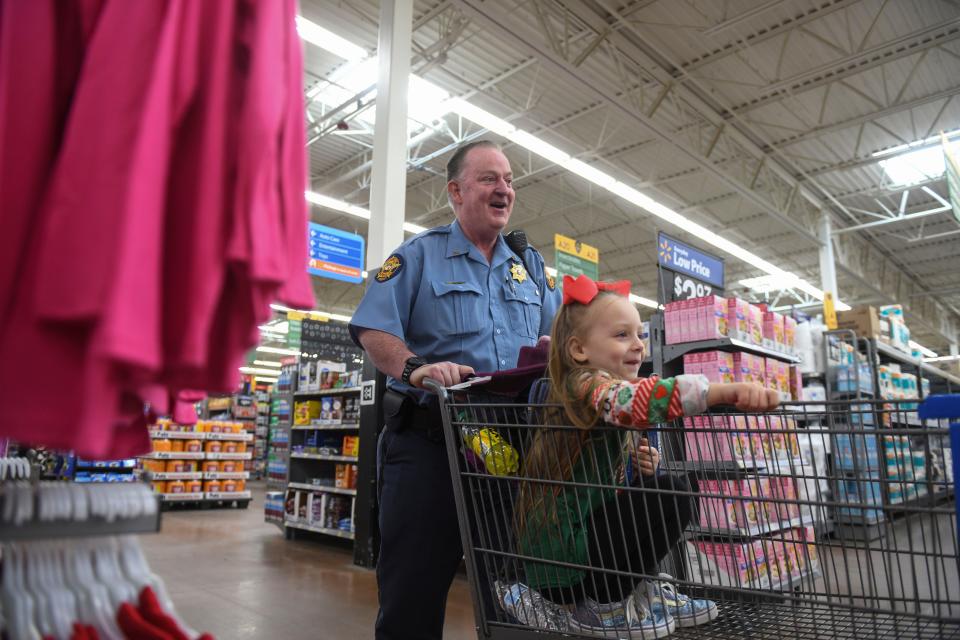 Deputy Greg Power pushes Aurora Lawson in a cart during the Columbia County SheriffÕs Office Day with a Deputy at Walmart on Thursday, Dec. 21, 2023.