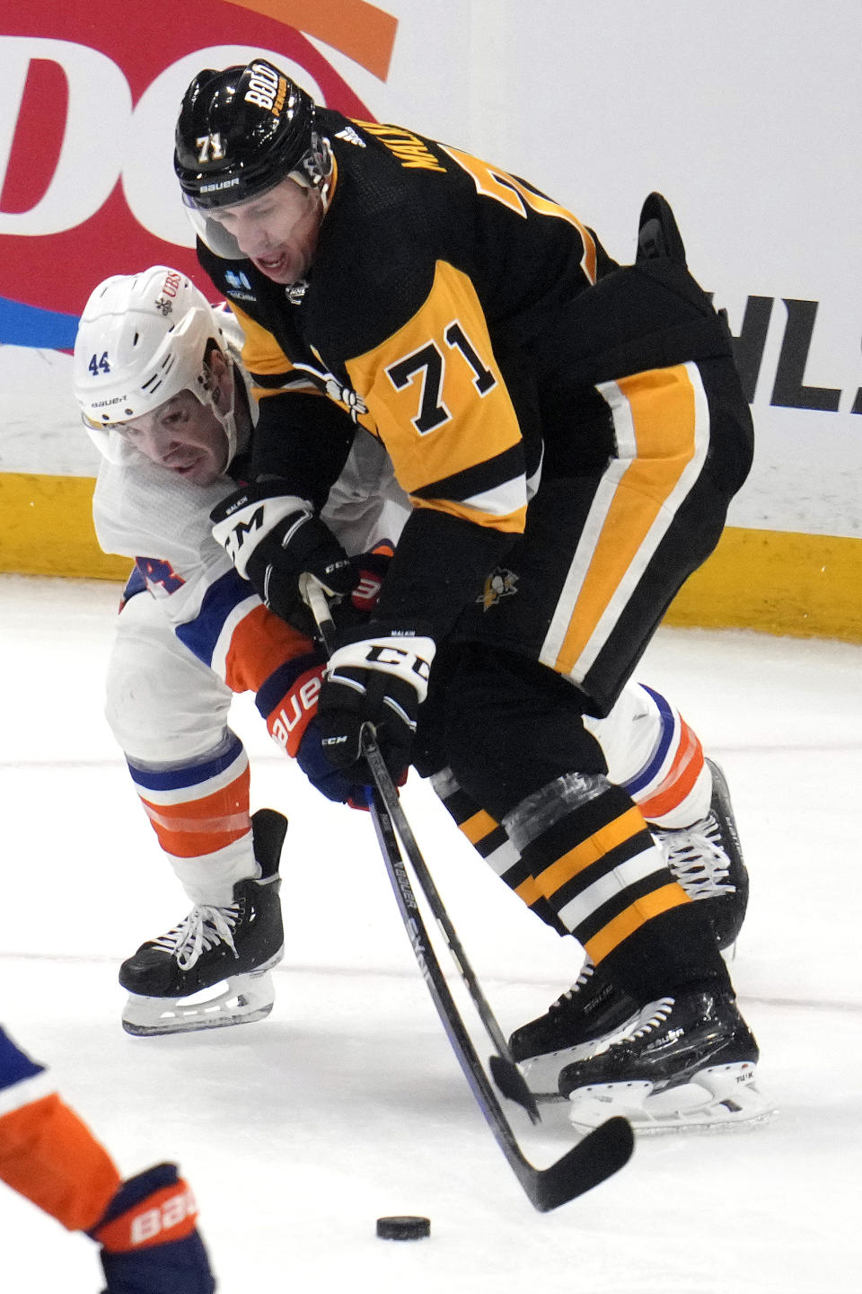 Pittsburgh Penguins' Evgeni Malkin (71) and New York Islanders' Jean-Gabriel Pageau battle for the puck during the first period of an NHL hockey game in Pittsburgh, Tuesday, Feb. 20, 2024. (AP Photo/Gene J. Puskar)