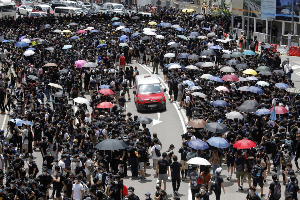 A taxi makes its way through a crowd of protesters gathered on a street near government offices in Hong Kong Friday, June 21, 2019. Several hundred mainly student protesters gathered outside Hong Kong government offices Friday morning, with some blocking traffic on a major thoroughfare, after a deadline passed for meeting their demands related to controversial extradition legislation that many see as eroding the territory's judicial independence. (AP Photo/Kin Cheung)