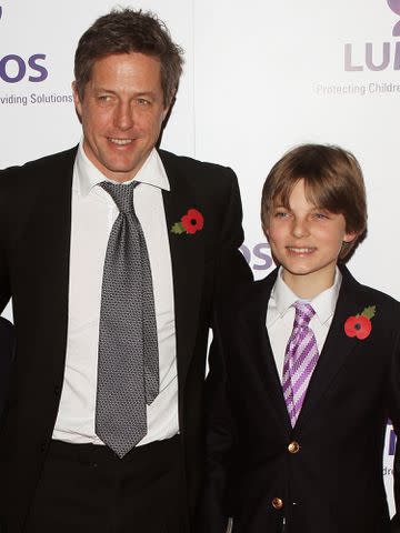 <p>David M. Benett/Getty</p> Elizabeth Hurley's son Damian Hurley with his godfather Hugh Grant at a Lumos fundraising event hosted by J.K. Rowling on Nov. 9, 2013 in London, England