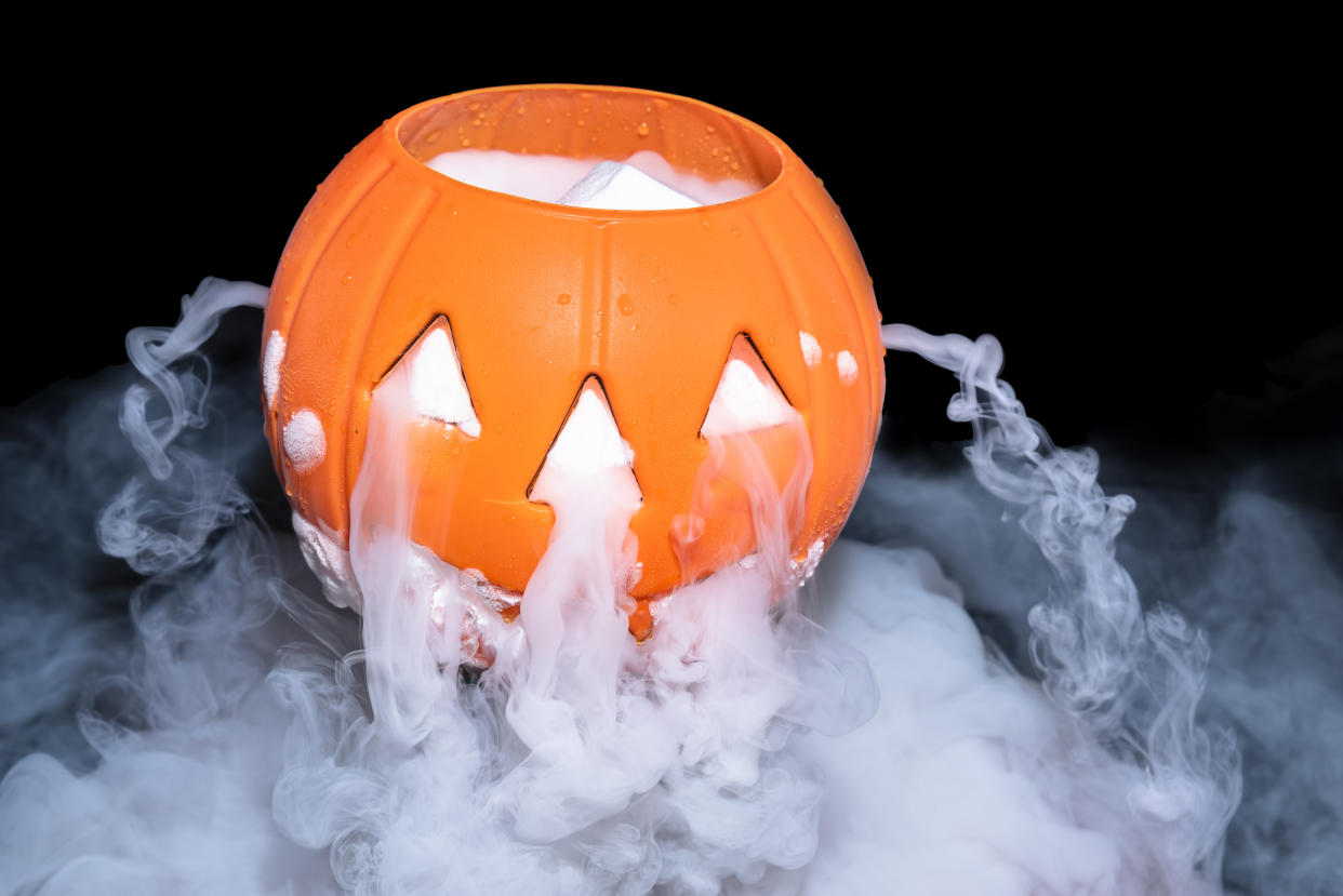 Halloween concept with pumpkin lantern & smoky the effect of dry ice on darkness background