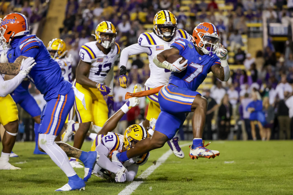 Florida running back Trevor Etienne (7) breaks a tackle by LSU safety Ryan Yaites (21) on a touchdown run during the second half of an NCAA college football game in Baton Rouge, La, Saturday, Nov. 11, 2023. (AP Photo/Derick Hingle)