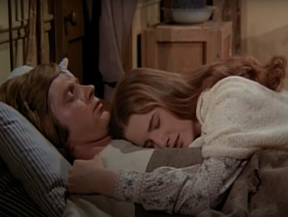 Melissa Gilbert lying on Dean Butler's chest in a scene from the show