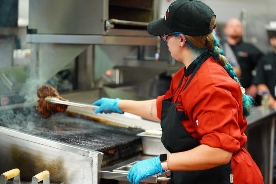 Kylie Hall shows off her grilling skills, perfectly cooking a porterhouse steak to medium at LongHorn Steakhouse’s Steak Master Series Championship in Orlando, Fla. May 26, 2023.