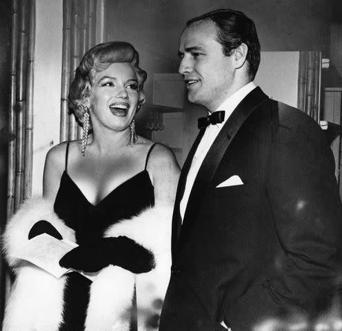 <p>Pictorial Parade/Archive Photos/Getty Images</p> Marilyn Monroe and Marlon Brando attending a party in New York City in 1956.