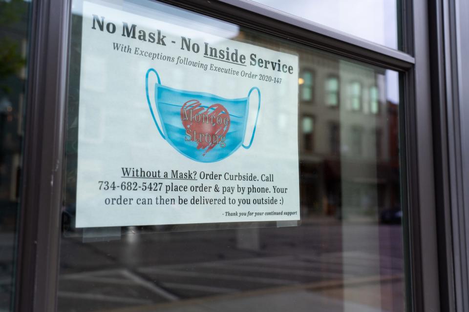 A sign on the door at Agua Dulce Coffee & Tee in downtown Monroe supports the wearing of masks in the business on Wednesday, May 5, 2021.