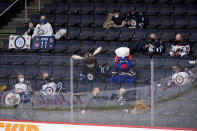 Winnipeg Jets' mascots sit with fans as they watch during the first period of an NHL hockey game against the Florida Panthers in Winnipeg, Manitoba, Tuesday, Jan. 25, 2022. (Fred Greenslade/The Canadian Press via AP)