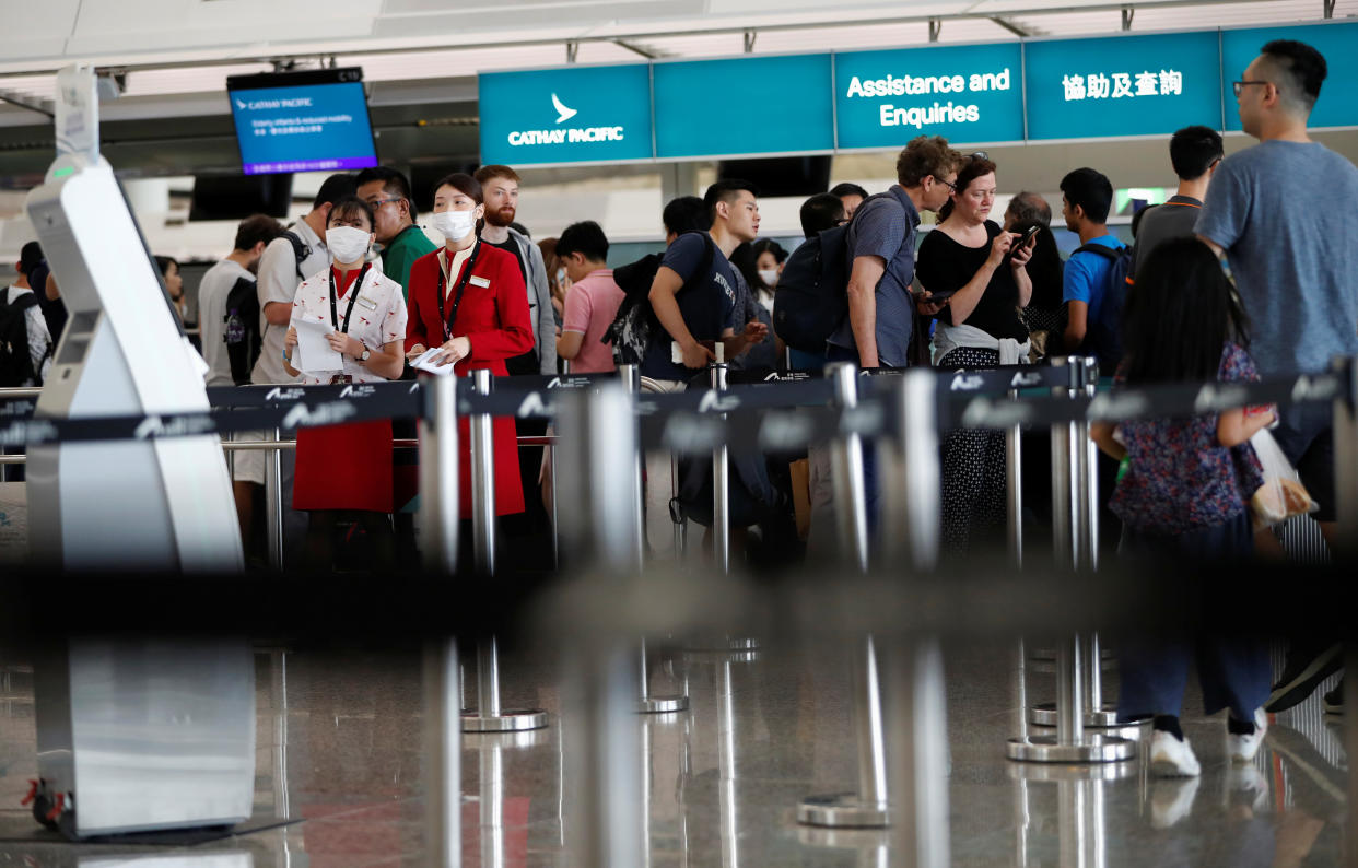 Passengers queue at Cathay Pacific's counters a day after the airport was closed due to a protest, at Hong Kong International Airport, China August 13, 2019. REUTERS/Issei Kato