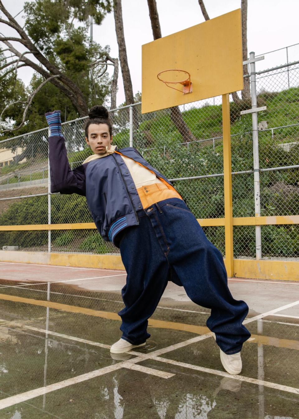 A model on a basketball court wears a navy bomber.