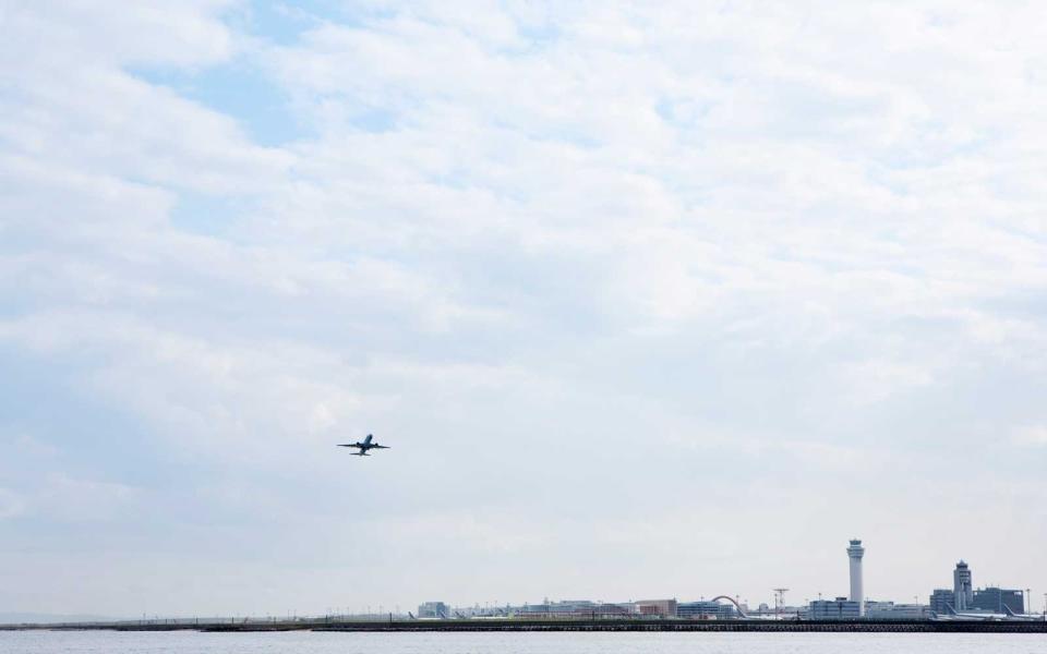 An air plane taking off from  airport on the seashore.