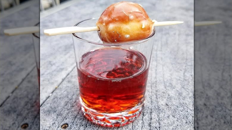 A cocktail garnished with a donut hole