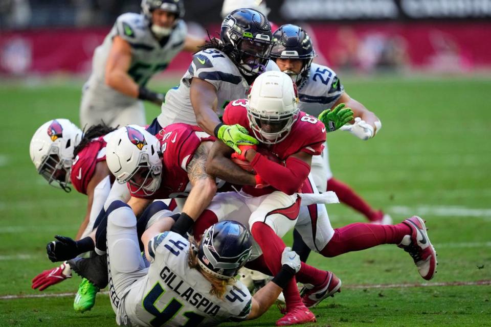 Arizona Cardinals’ Greg Dortch, middle, is tackled as he returns a kickoff against the Seattle Seahawks during the first half of an NFL football game in Glendale, Ariz., Sunday, Nov. 6, 2022. (AP Photo/Matt York)