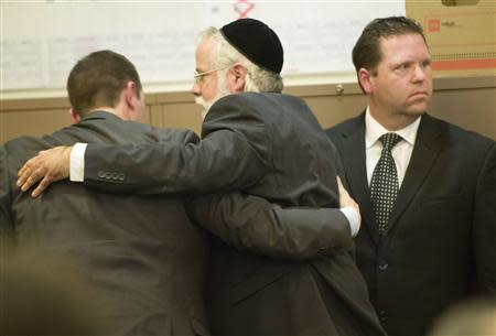 Former Fullerton police officer Jay Cicinelli (R) looks back into the court gallery as his attorney Michael Schwartz (C), embraces co-counsel after the not-guilty verdict is read in the Kelly Thomas murder trial in Santa Ana, California January 13, 2014. REUTERS/Mindy Schauer/Pool