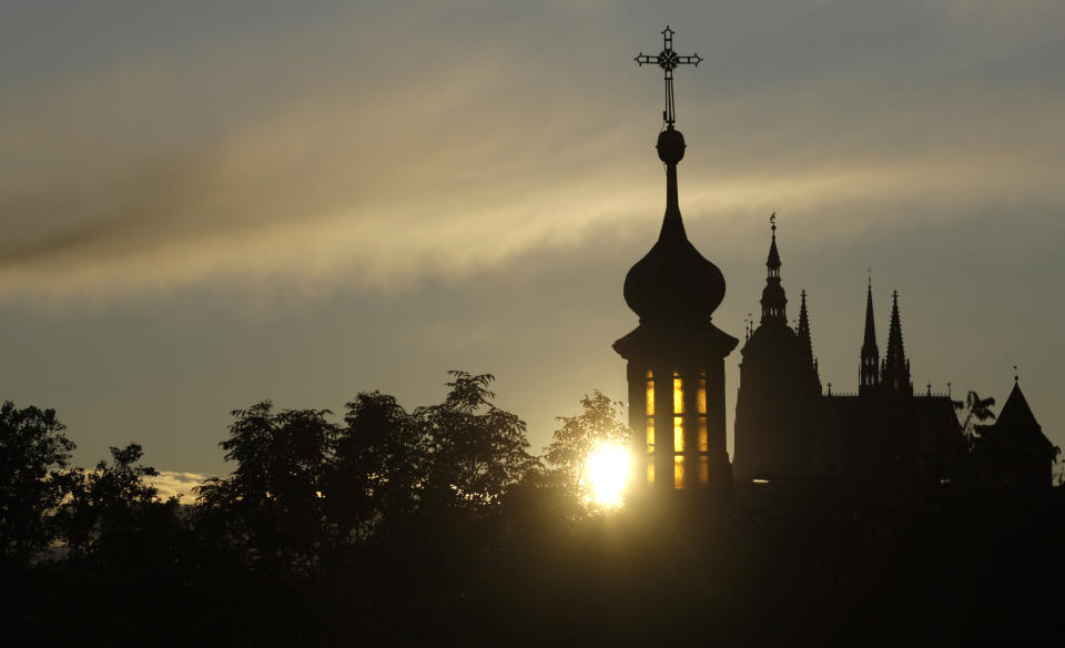 In this file picture taken on Oct. 13, 2009, the sun sets behind the St. Vitus cathedral in Prague, Czech Republic. On Wednesday Jan. 23, 2019, the lower house of Czech Parliament has approved a proposal drafted by the Communist Party to tax the compensation that the country's churches receive for property seized by the former Communist regime. (AP Photo/Petr David Josek, File)