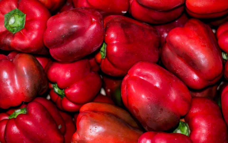 overhead view of a box of red peppers in a box at a market / greengrocer. Red color. Fresh and ripe vegetables, organic farming.