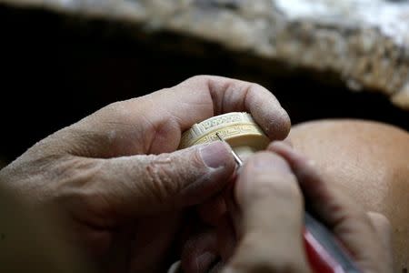 A worker crafts an ivory product from government registered ivory tusk inside a factory in Hong Kong, China June 27, 2016. REUTERS/Bobby Yip