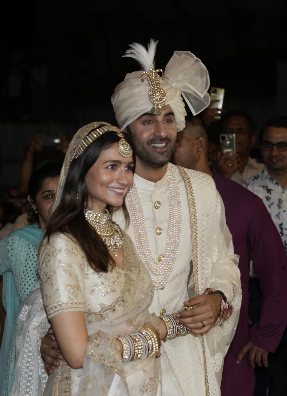 Bollywood actors Ranbir Kapoor, right and Alia Bhatt pose for photographs after their wedding outside their residence in Mumbai, India, Thursday, April 14, 2022. (AP Photo/Rajanish Kakade)