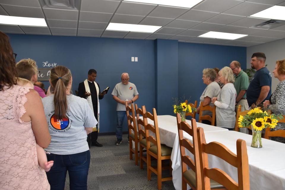 Father Sengole Gnanaraj, administrator of St. Elizabeth Ann Seton Parish in Richmond, says a prayer before using holy water to bless David’s House, a new ministry of the Tri-County Good Samaritans St. Vincent de Paul conference, in Richmond on Sept. 10. Tony Talbert, president of the counsel, looks on from behind.