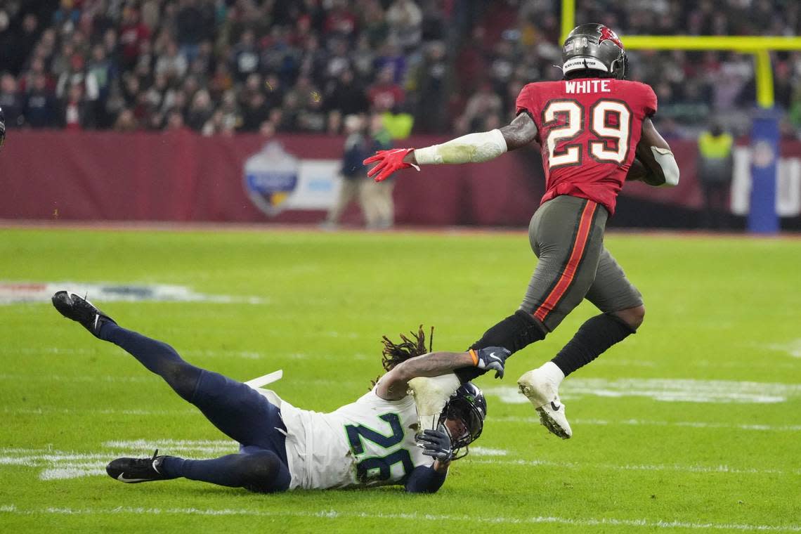 Tampa Bay Buccaneers’ Rachaad White (29) is tackled by Seattle Seahawks’ Justin Coleman (28) during the second half of an NFL football game, Sunday, Nov. 13, 2022, in Munich, Germany. (AP Photo/Matthias Schrader)