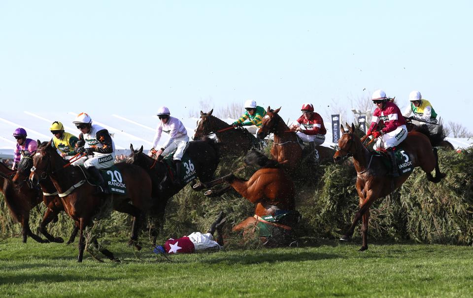 Jockey Patrick Slevin (centre) falls from Thunder and Roses during the Grand National