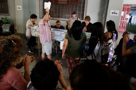 A polling station official shows a ballot paper after opening a ballot box during the presidential election in Santiago, Chile November 19, 2017. REUTERS/Cristobal Saavedra Vogel