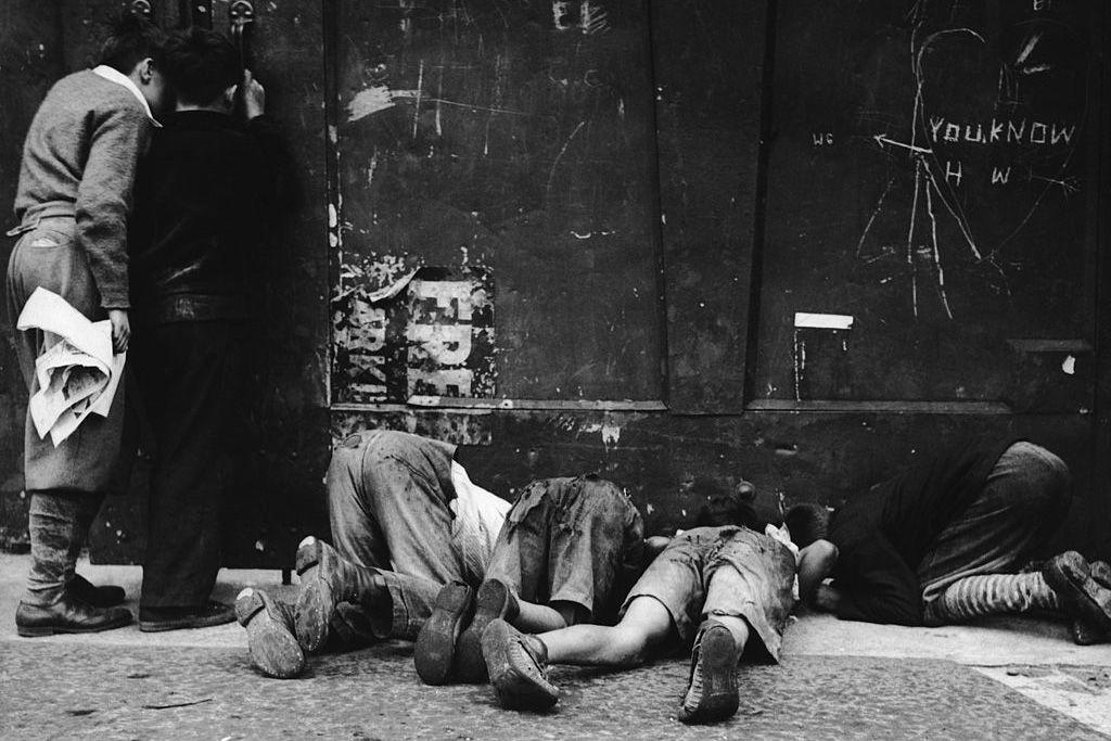 a group of boys peering under a gate, east side, buffalo, new york, circa 1925