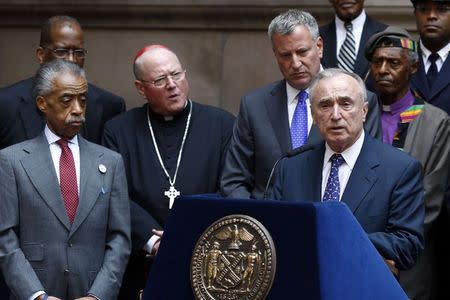 New York City Police Commissioner William Bratton (R) speaks next to Reverend Al Sharpton (L), Cardinal Timothy Dolan (2nd L) and New York City Mayor Bill de Blasio (3rd L) during a news conference after an interfaith roundtable meeting on strengthening police-community relations with members of the city's clergy in Manhattan, August 20, 2014. REUTERS/Eduardo Munoz