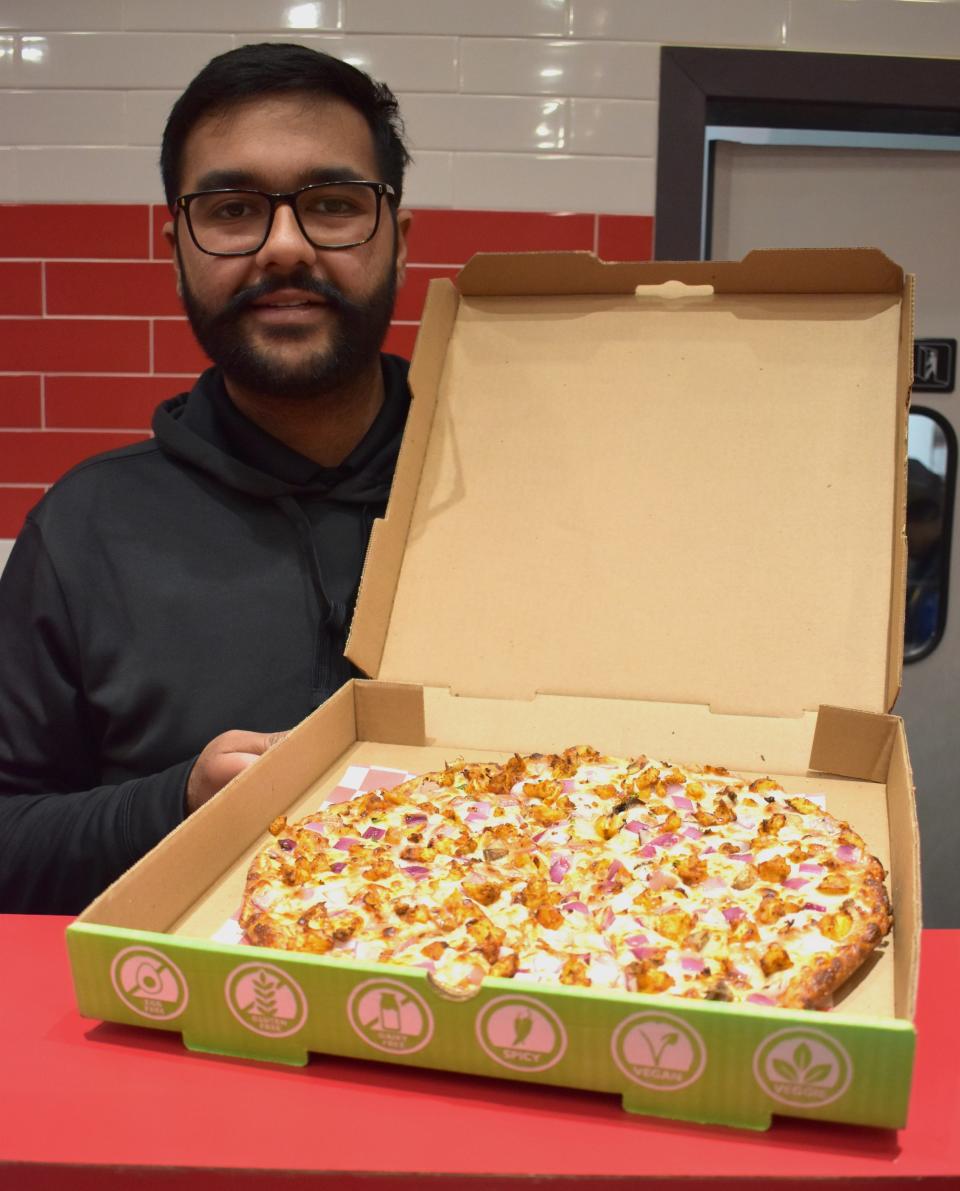 Japundeep Singh displays a tandoori chicken pizza at Pizza Twist in Cherry Hill.