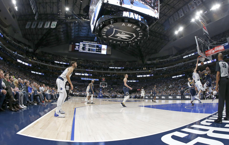 Dallas Mavericks center Boban Marjanovic (51) dunks next to Denver Nuggets forward Paul Millsap (4) during the second half of an NBA basketball game Wednesday, March 11, 2020, in Dallas. The Mavericks won 113-97. (AP Photo/Ron Jenkins)