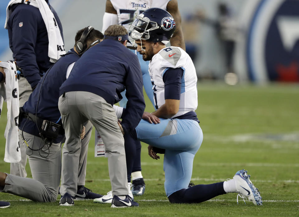 Marcus Mariota gets checked out by trainers after being sacked against the Redskins. (AP)