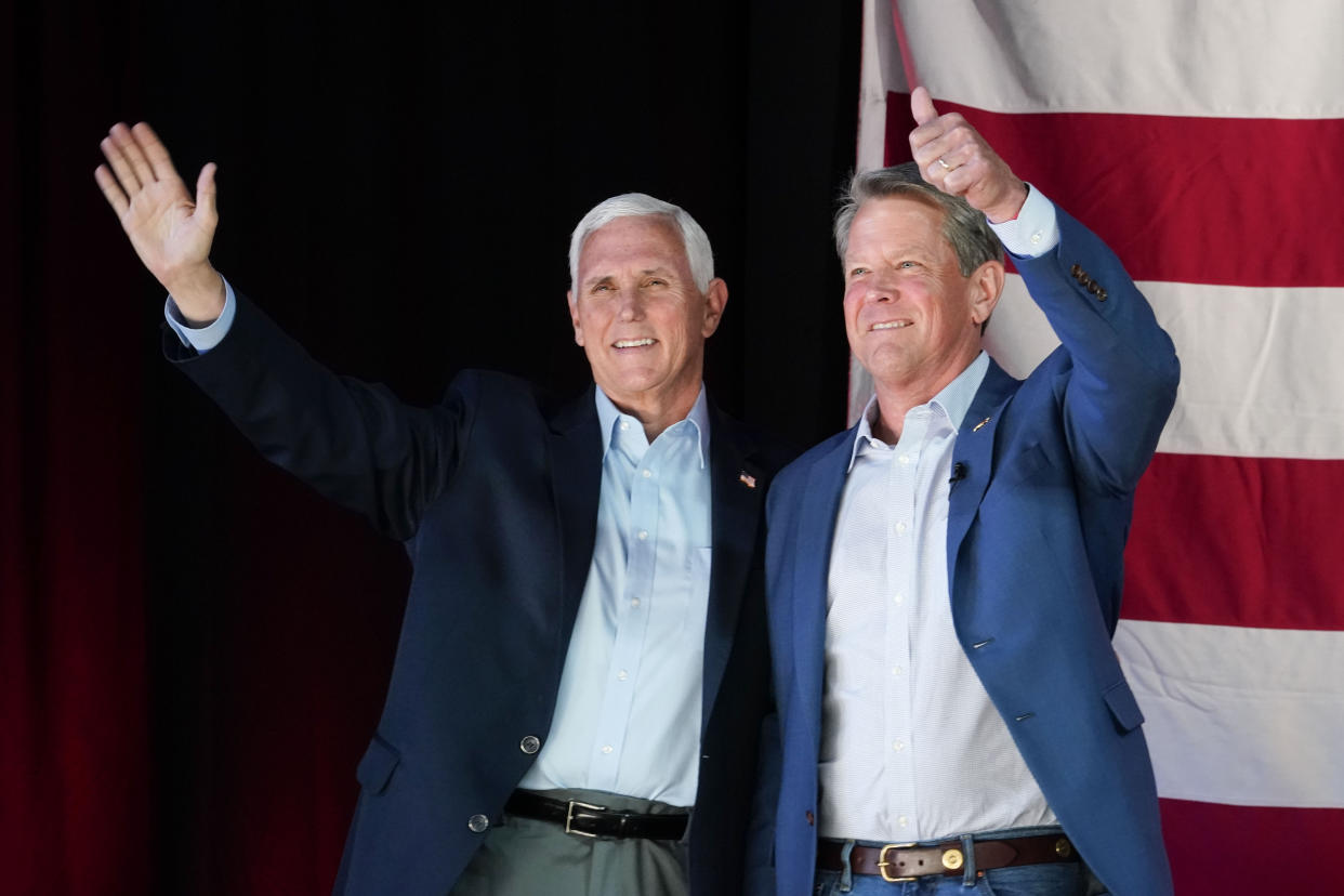 Former Vice President Mike Pence and Georgia Gov. Brian Kemp wave to the crowd at a rally.