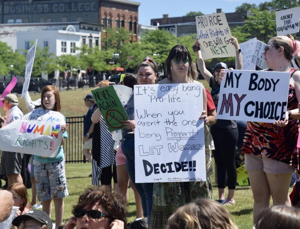 A pro-abortion rights protester holds a sign reading "It's easy being 'pro-life' when you aren't the one being pregnant, let women decide," during a protest along US-31 in front of the hole in downtown Petoskey on Sunday, July 3.