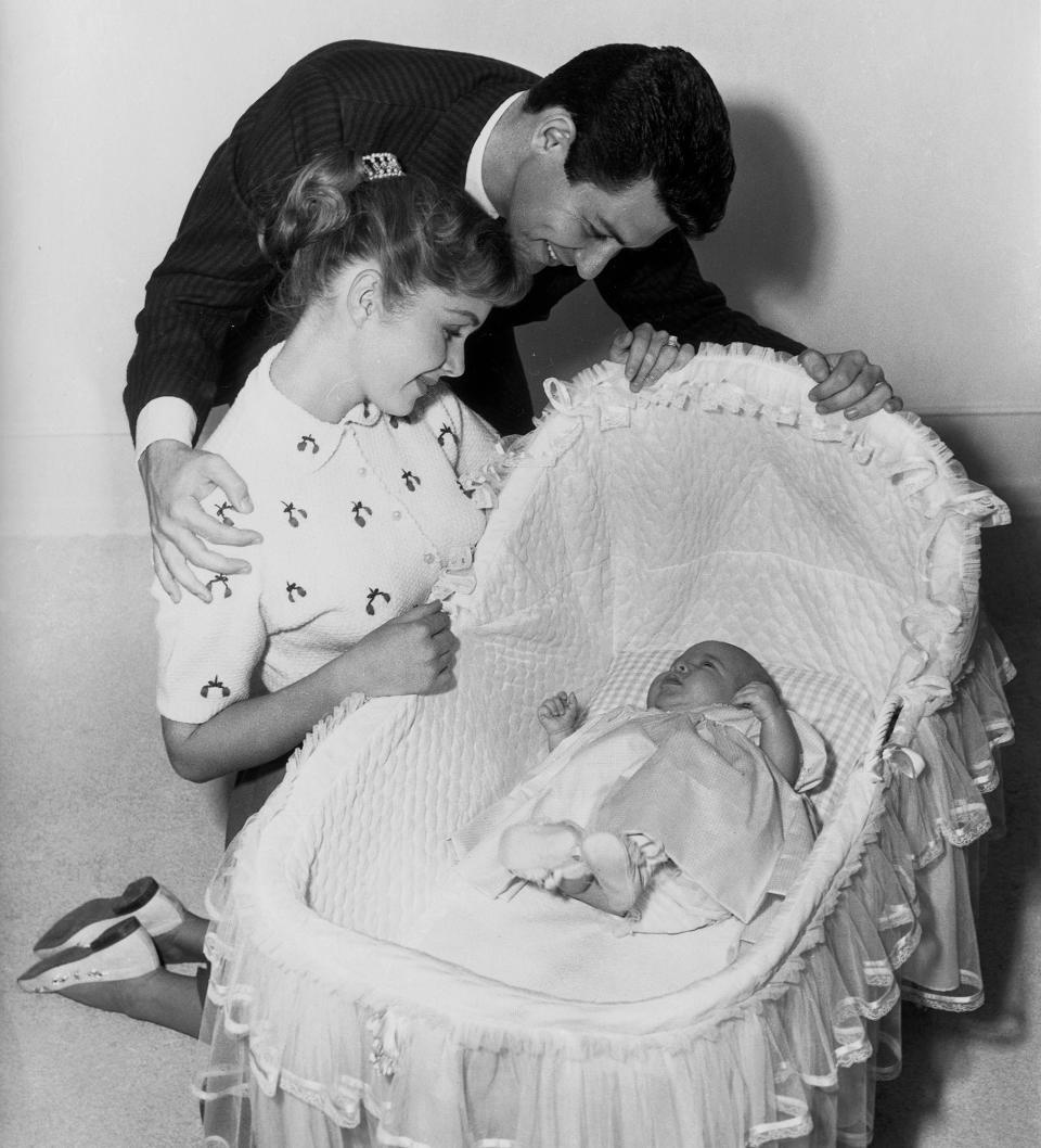 Carrie Fisher gazes up at her parents Debbie Reynolds and Eddie Fisher not long after her birth on Oct. 21, 1956.