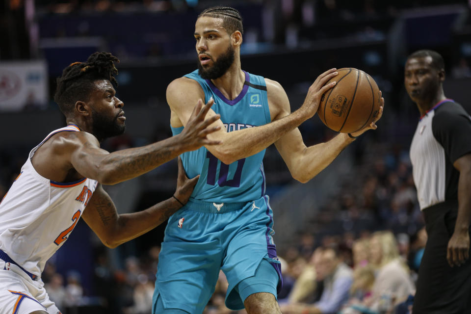 Charlotte Hornets forward Caleb Martin, right, keeps the ball from New York Knicks guard Reggie Bullock during the first half of an NBA basketball game in Charlotte, N.C., Wednesday, Feb. 26, 2020. (AP Photo/Nell Redmond)