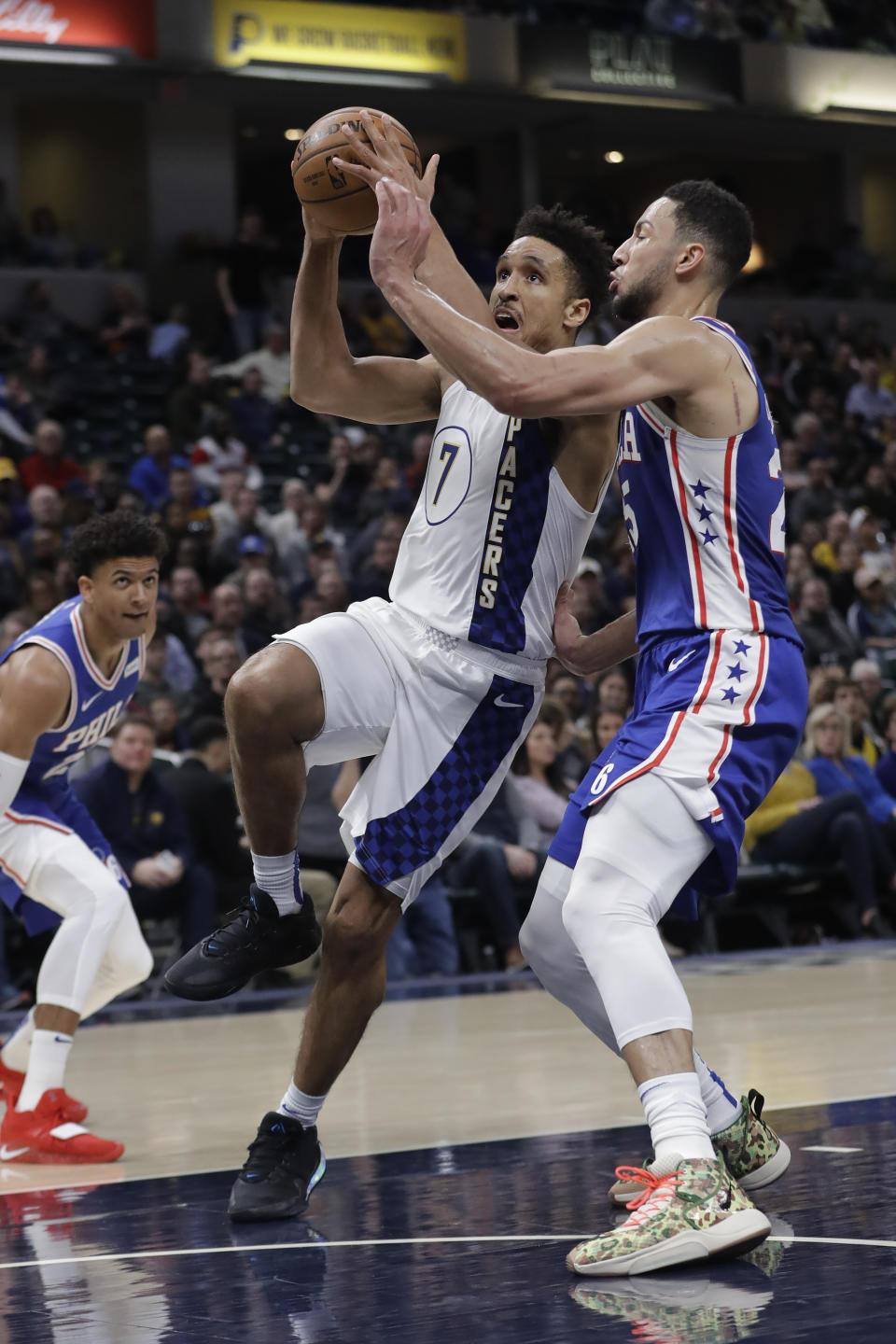 Indiana Pacers' Malcolm Brogdon (7) is fouled by Philadelphia 76ers' Ben Simmons (25) as he goes up for a shot during the first half of an NBA basketball game, Monday, Jan. 13, 2020, in Indianapolis. (AP Photo/Darron Cummings)