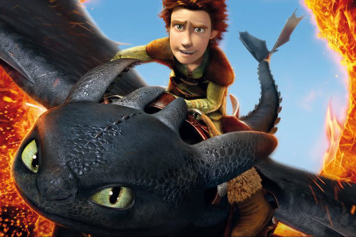 A boy rides on the top of a dragon.