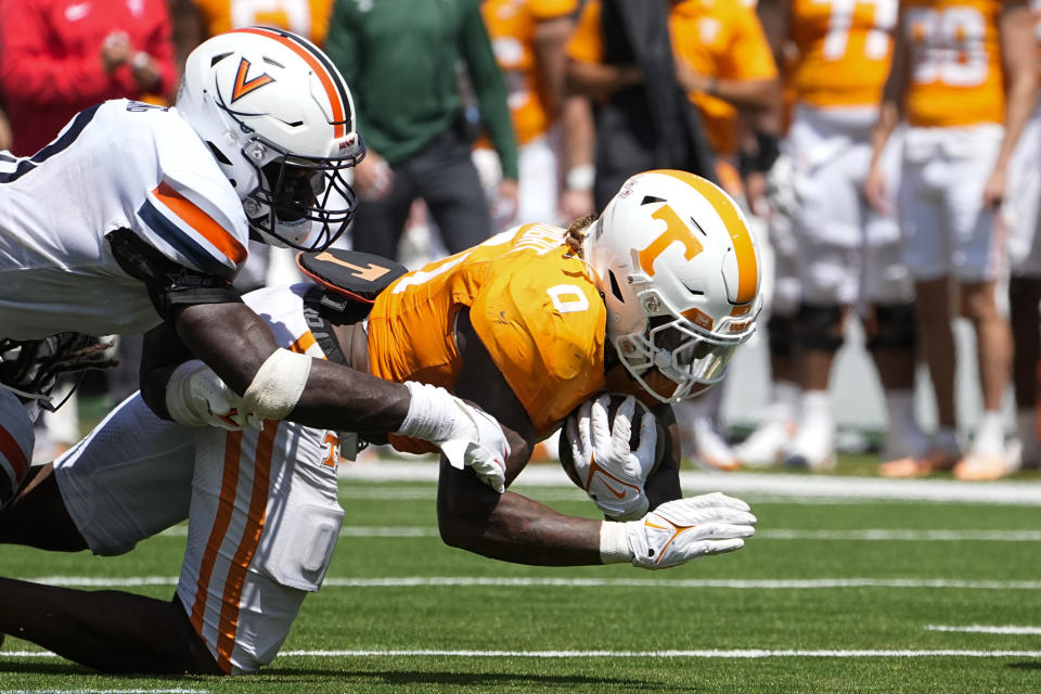 Virginia linebacker Langston Long, left, tackles Tennessee running back Jaylen Wright (0) as he dives for extra yards in the first half of an NCAA college football game Saturday, Sept. 2, 2023, in Nashville, Tenn. (AP Photo/George Walker IV)