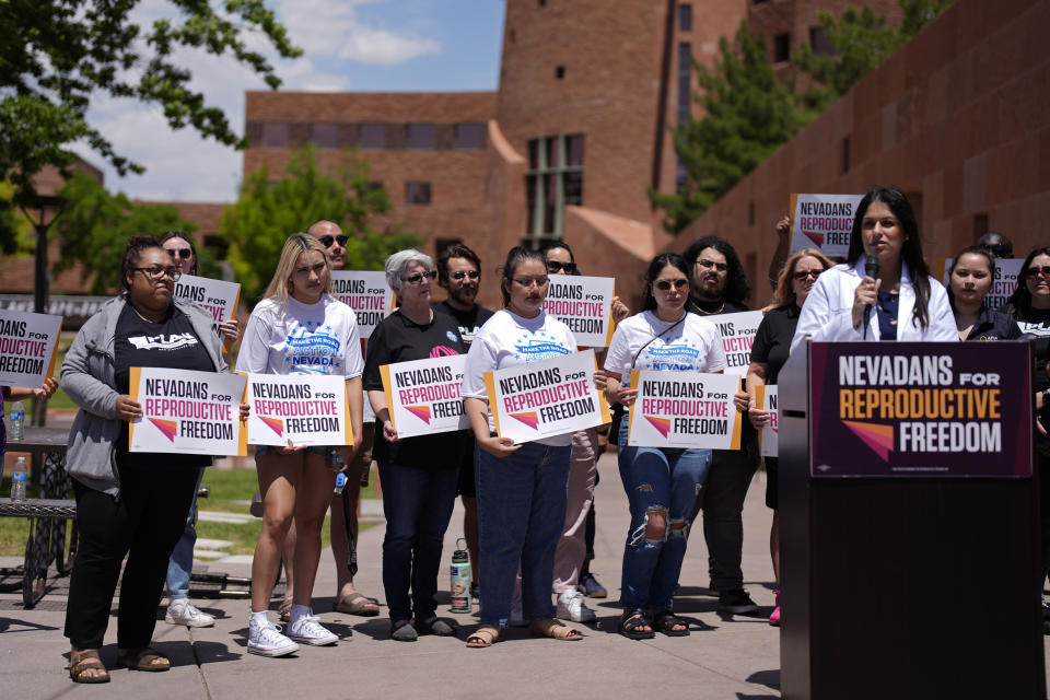 FILE - People hold signs during a news conference by Nevadans for Reproductive Freedom, Monday, May 20, 2024, in Las Vegas. Voters in four states will consider adding abortion protections to their state constitutions this year, and there are pushes for measures in several others. (AP Photo/John Locher, File)