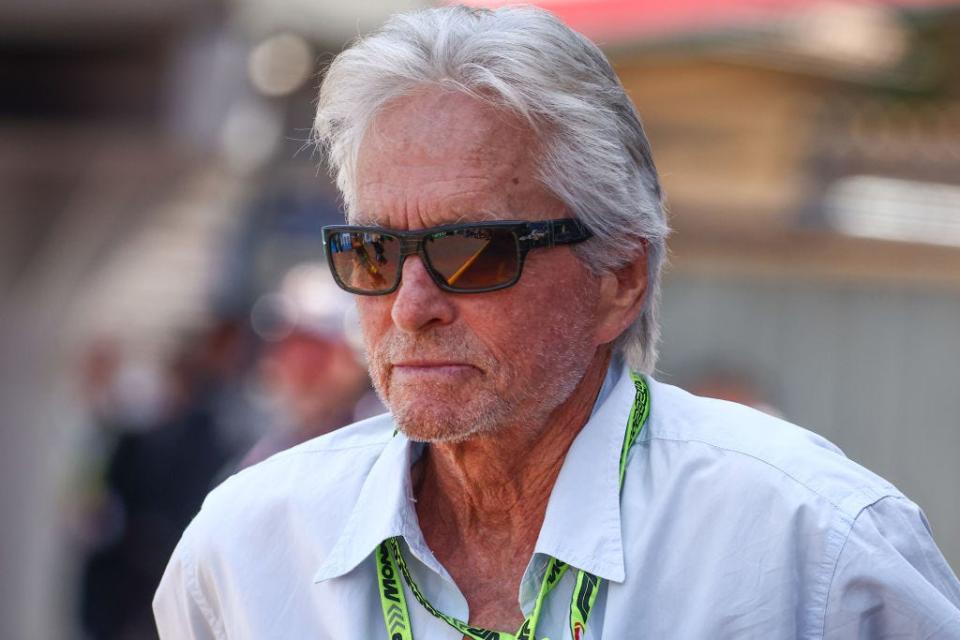 Michael Douglas wears sunglasses and stands outside.