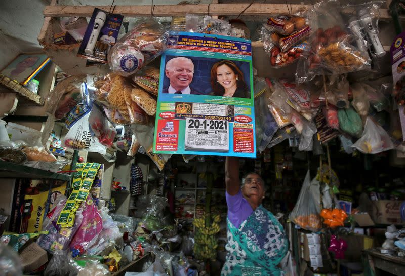 A calendar with photos of U.S. President-elect Joe Biden and Vice President-elect Kamala Harris hangs in a shop in the village of Thulasendrapuram